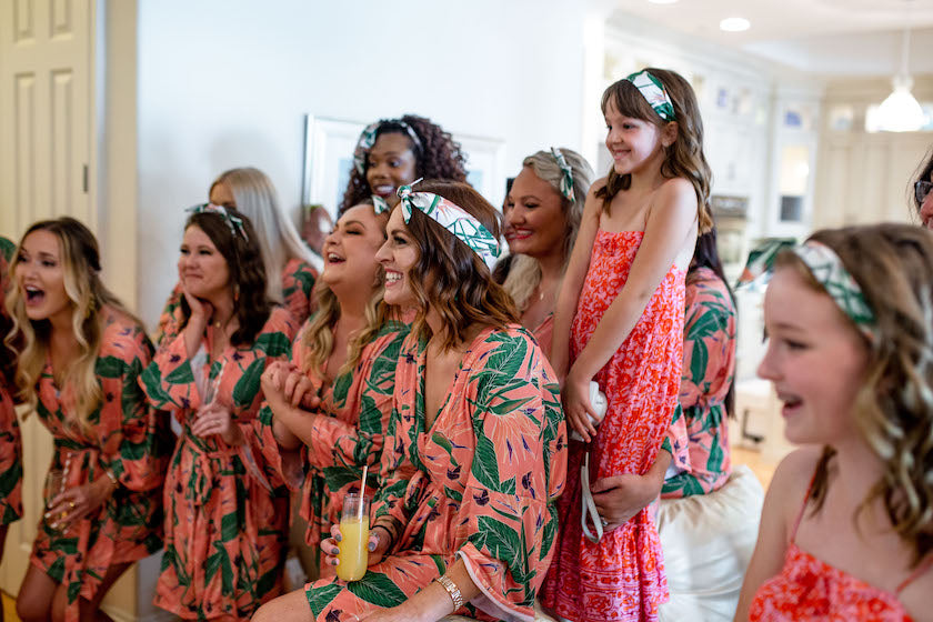 bridesmaids laughing wearing coordinating bridal robes and hair scarves