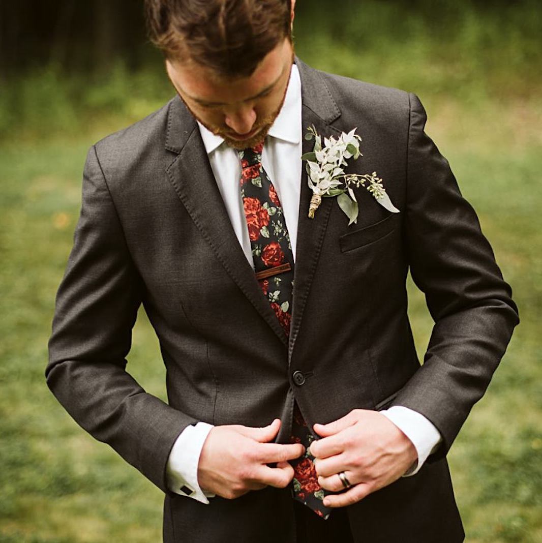groom wearing floral necktie and grey suit