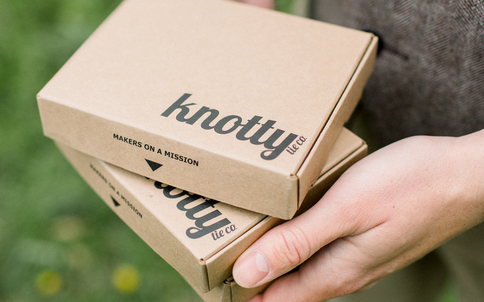 groom holding necktie box to give to groomsmen as gift